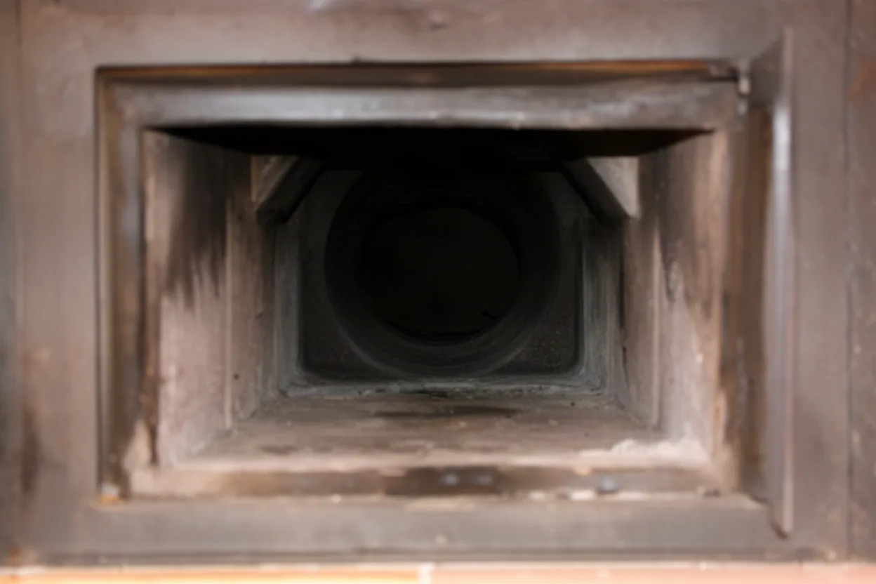 inside a fireplace looking up into the dark chimney flue opening, wide view, muted colors